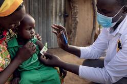 Anan holding her 3-year-old son Peter while he is examined