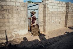 Woman walking next to brick house