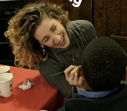 GenR volunteer doing face painting with a youth participant