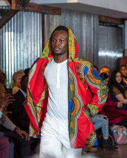 A man in African designs walks down the runway at the Hope Couture fashion show