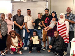 A group of IRC clients pose together with their IRC instructor at the Phoenix office to celebrate the completion of their course.