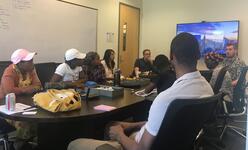 Refugee youth meet and IT department of Celtic Bank in a office room.