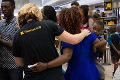 An International Rescue Committee caseworker greets a newly arrived refugee family at the Salt Lake City Airport