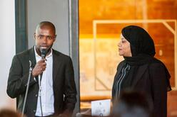 Osman and Naima presenting to a crowd.