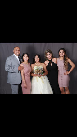 Alex poses for a photo with her twin sister, her 15-year-old sister, and their parents