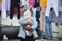 Alma, an asylum seeker from Guatemala, and her daughter wait for their laundry to dry in the outdoor living space of a shelter in Ciudad Juarez. 