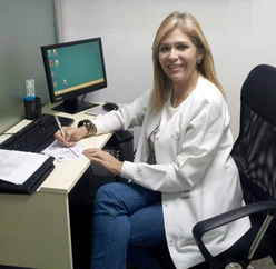 Dr. Edna Patricia Gomez poses at her desk in front of a computer in the IRC sexual and reproductive health care in Cúcuta, Colombia.  