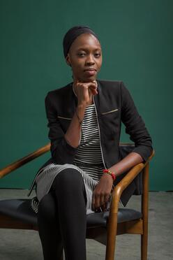 Portrait of Amira from Central African Republic sitting in a chair. 