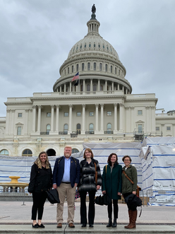 Five IRC staff standing in front of the US Capitol building.