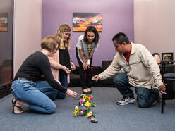 A group of four people with a display of flowers and rocks