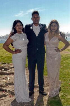DACA recipients Lupe, her brother and sister pose for a photo with their arms around each other at a festive family event