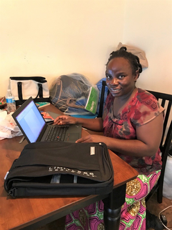 Flavia sitting at the table with her computer.