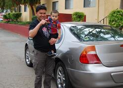 Father and son holding the keys to their new car.