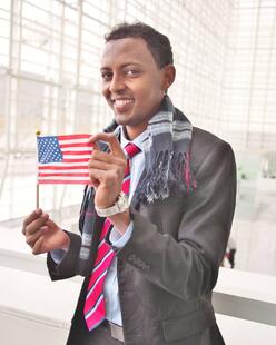 A man holding an American flag celebrates in Phoenix after obtaining U.S. citizenship with the help of IRC.