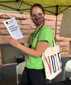 Tatjana Andrews holding voter forms in Civic Engagement tent.