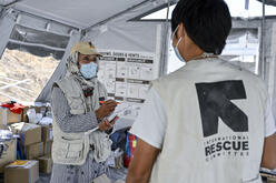 Two IRC volunteers talk in a tent in a Greek refugee camp