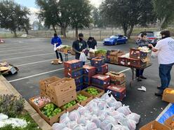 4 members of the Muslim Community Center East Bay organize boxes of food in a parking lot for weekly deliveries to over 200 families 