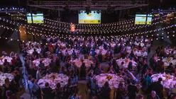 An aerial shot of Breaking Bread in 2019, showing a large, dimly lit room full of people sitting around multiple large tables. 