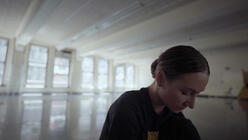 Christine Shevchenko, her head and shoulders seen as she bends to prep for a rehearsal in a dance studio