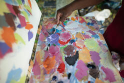 A closeup of artist Muyambo Marcel Chishimba's palette, showing many colors of oil paint