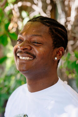 A close-up shot of Koffi, smiling and looking to the right