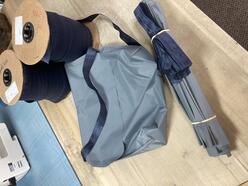 Take home kit showing large grey fabric and rolls of black fabric