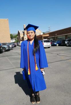 Edith in a blue graduation gown and cap