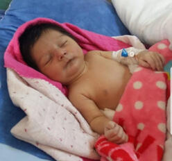 Baby Nasrin sleeps in the hospital in Iraq where she is being treated for a heart condition.