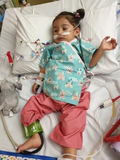 Nasrin in a hospital bed as a toddler