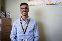 A portriat of Shir Zad in the IRC office. He is wearing a button down shirt, glasses and an IRC lanyard, and is smiling. 