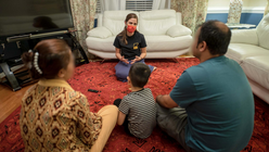 Newly arrived family gathers in their living room. 