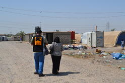 Community representatives walk through the camp