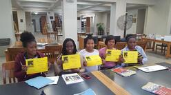 Women In Action participants graduate and show their diplomas.