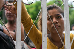 A woman in a group of Colombians and Venezuelans waiting outside a soup kitchen