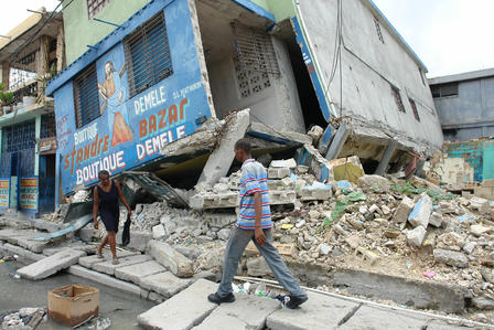 People walk past earthquake-damaged buildings in Port-au-Prince, Haiti in 2010
