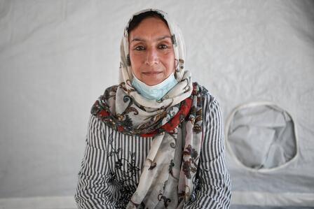Rahima sits inside a tent in the refugee camp where her family lives in Lesbos, Greece