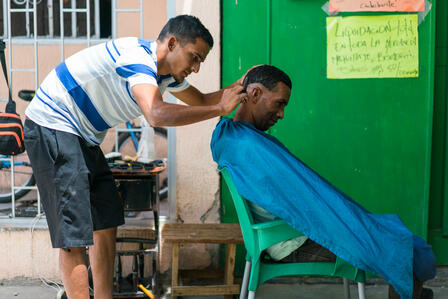 Antonio (not his real name), from Venezuela, cuts hair in Cúcuta, Colombia Antonio gives a man a haircut