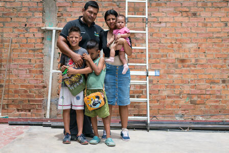 Sofia and Luis and their family Sofia and Luis stand with their two young sons and baby daughter