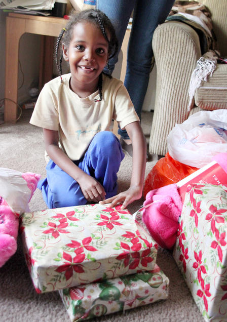 A refugee child opens a present