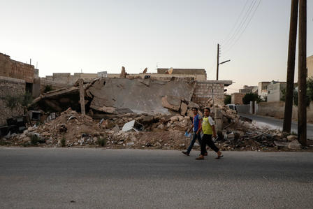 Boys walk past destroyed buildings in war-ravaged Idlib, Syria
