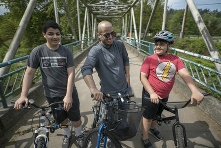 Taghreed's husband with their two sons on bikes on a bridge