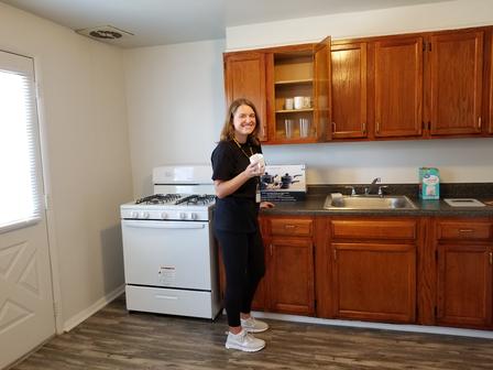 Lauren helps to set up an apartment with all the necessary items before a newly-arrived refugee family moves in.