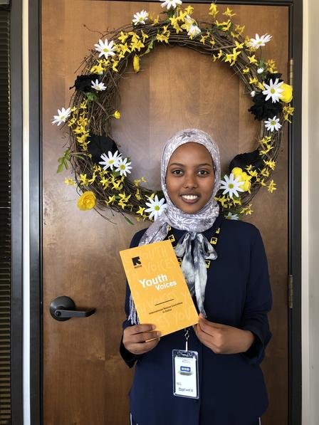 IRC in Dallas' 2019 Mayors Intern Rahmo Bare holds a copy of Youth Voices IRC in Dallas' 2019 Mayors Intern Rahmo Bare holds a copy of Youth Voices