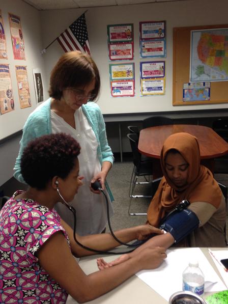 The IRC's first cohort of English for Nursing Assistants students was small but mighty! Class participants work with the CNA instructor to check each others blood pressure.
