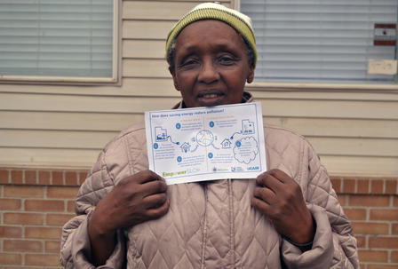 Cecile is a Utah refugee who attended a Utah Clean Energy class a year ago. Woman holding a clean energy sign.