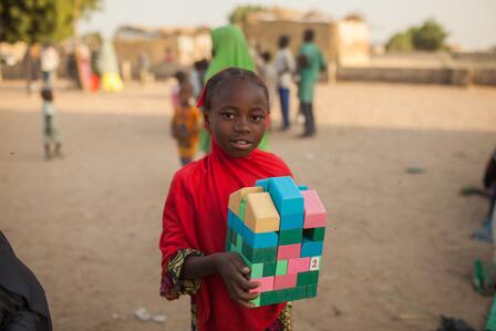 A child holds blocks at an IRC Safe healing and Learning Space in northeast Nigeria.