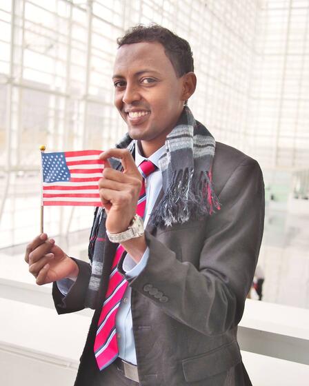 A man holding an American flag celebrates in Phoenix after obtaining U.S. citizenship with the help of IRC.