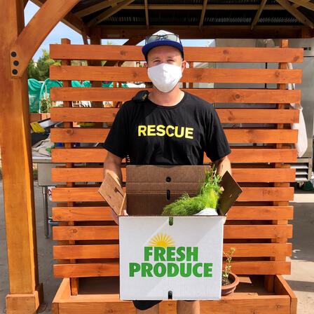 Isaac, an IRC staff member, holds a Fresh Produce Box. Isaac, an IRC staff member, holds a Fresh Produce Box.