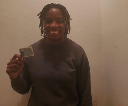 Roxsene with her new CDL card. A picture of Roxsene, a client in NJ, smiling and holding her new Commercial Driver License.