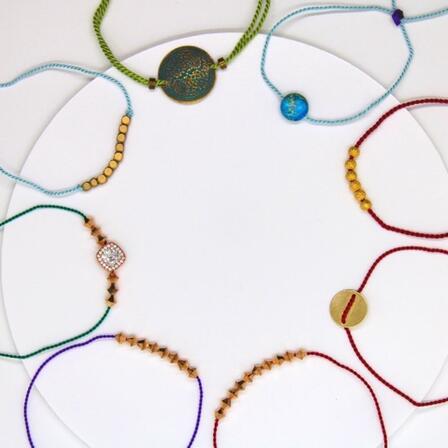 Eight colorful, delicate bracelets featuring decorative gems and charms by new American entrepreneur, Zubaidah.